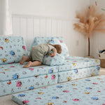 Toddler using Baby Shark™ x Roo & You™ Stepping Stones as a pillow while pretending to sleep.