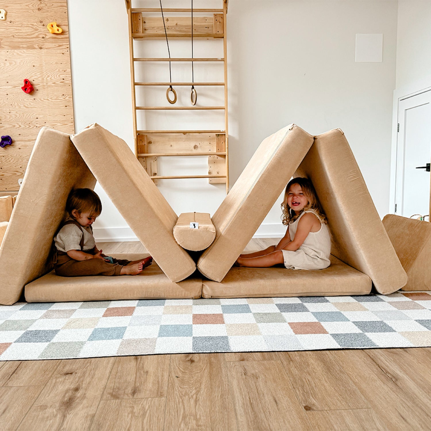 Two kids sitting inside a creative fort built from a modular foam play couch for kids—durable Canadian floor couch designed for safe indoor fun and imaginative play.