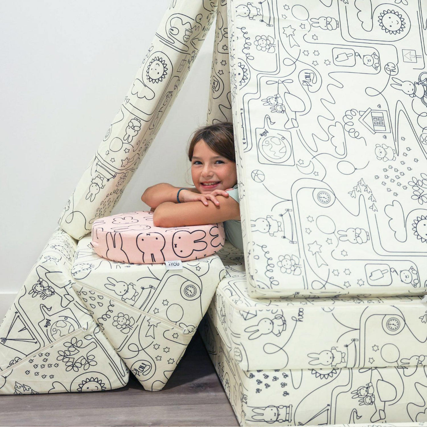 Little girl playing with Miffy™ x Roo & You™ Joey Play Couch covered in bunny print.